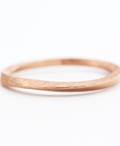 Two gold wedding bands, one is a twisted band and the other is a simple band.