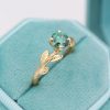 Green moissanite cushion cut ring with nature inspired theme in 14k yellow gold