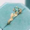 Green moissanite cushion cut ring with nature inspired theme in 14k yellow gold