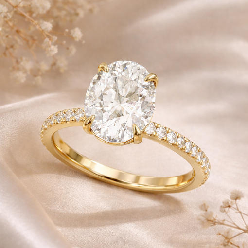 3 carat oval lab grown diamond engagement ring in yellow gold with pavé diamond band on soft beige background